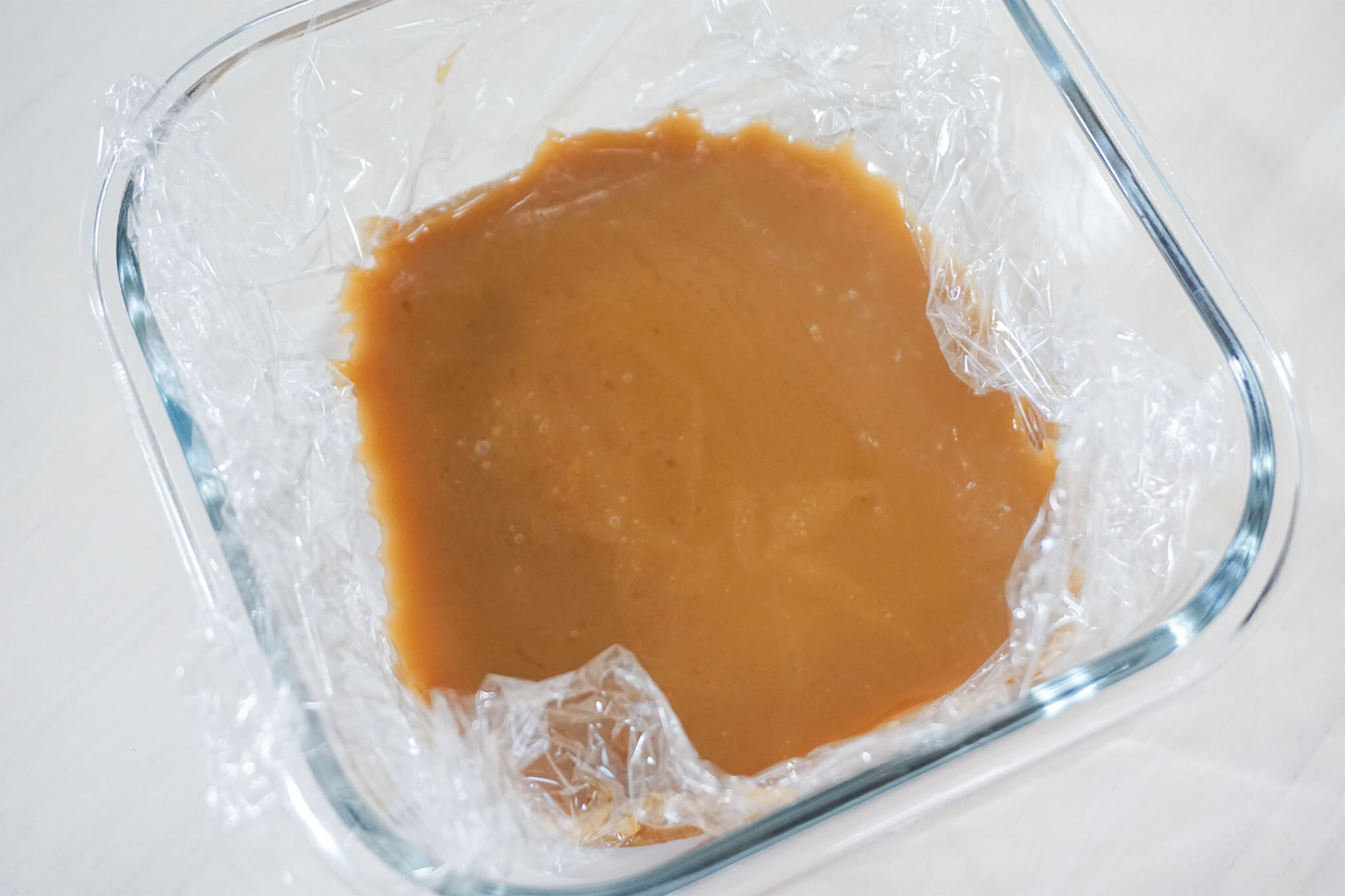 ラップを敷いた耐熱ガラス容器に生キャラメルを流し入れた様子