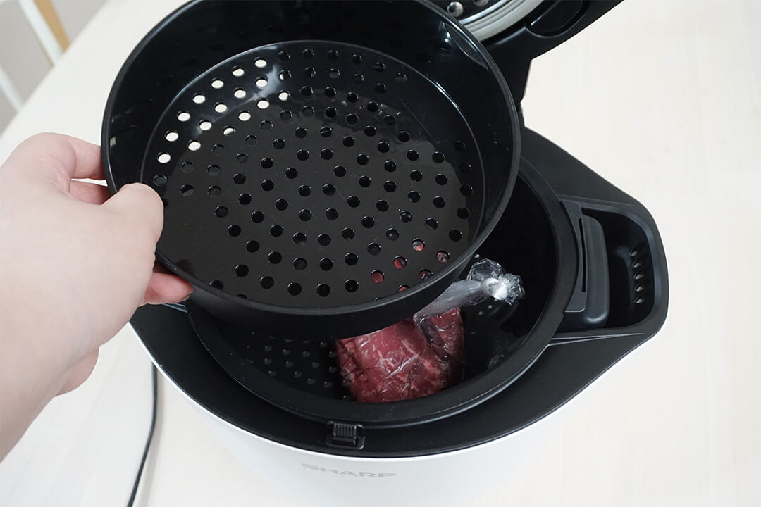 水と肉を入れたホットクックの内釜に蒸しトレイを乗せている様子