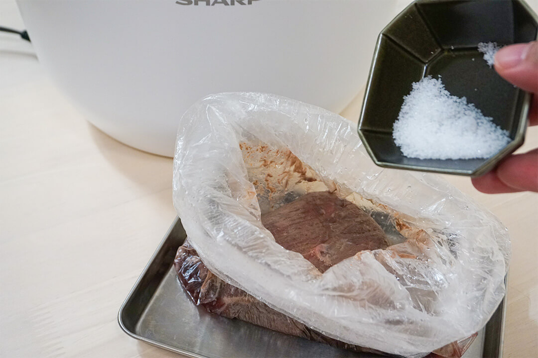 加熱後のローストビーフの袋に塩を入れている様子