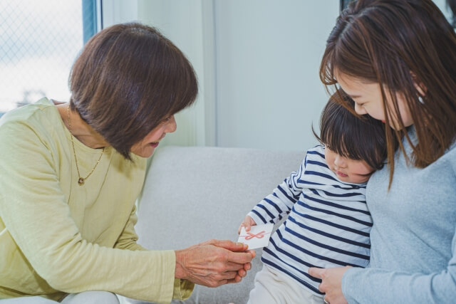 おばあちゃんからお年玉をもらう小さな子ども